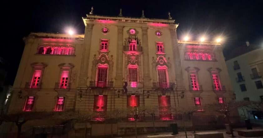 El Ayuntamiento brilla en rojo carmesí por la llegada de los Reyes de España
