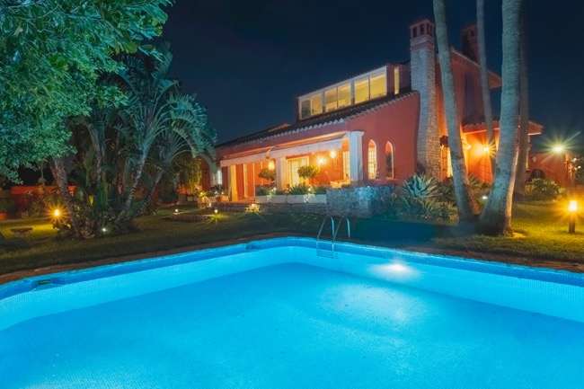 Fotografía nocturna de una villa con piscina en Chiclana, Cádiz
